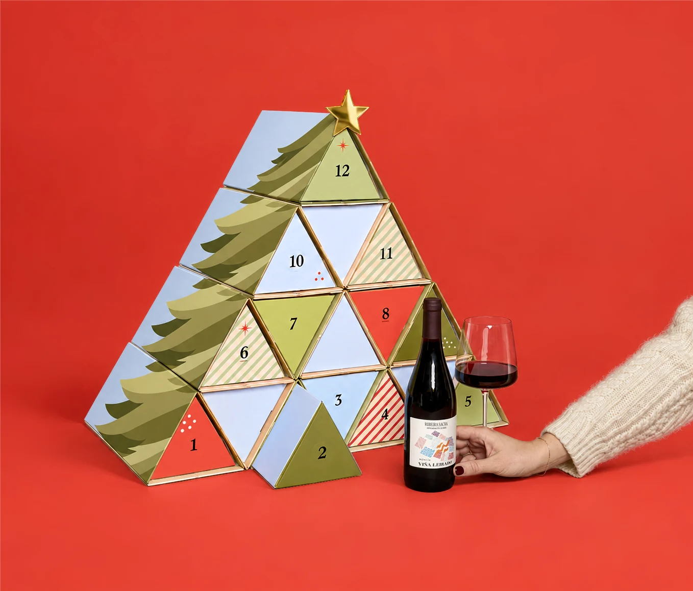 Tree-shaped advent calendar with numbered wine boxes and a bottle of red wine