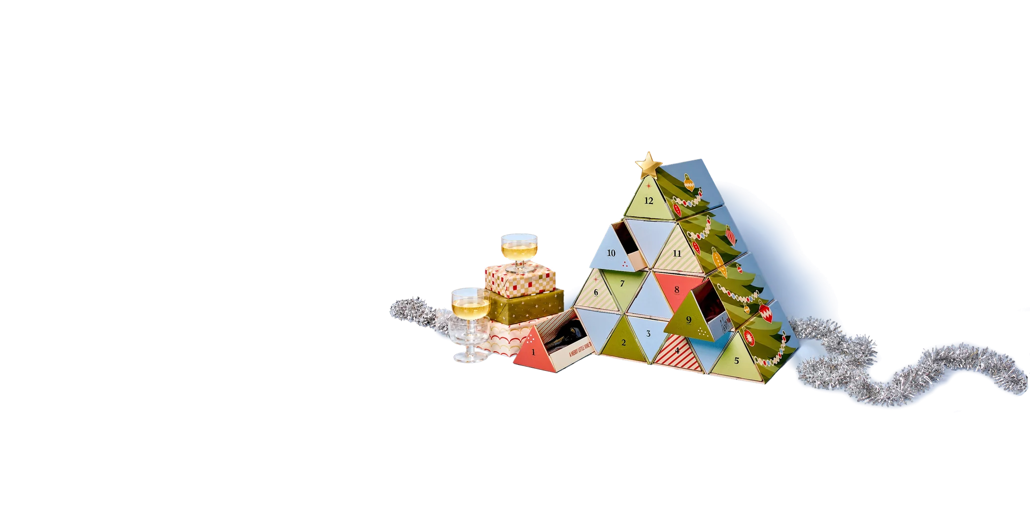 Wine advent calendar stacked into a Christmas tree beside sparkling wine, gifts and tinsel