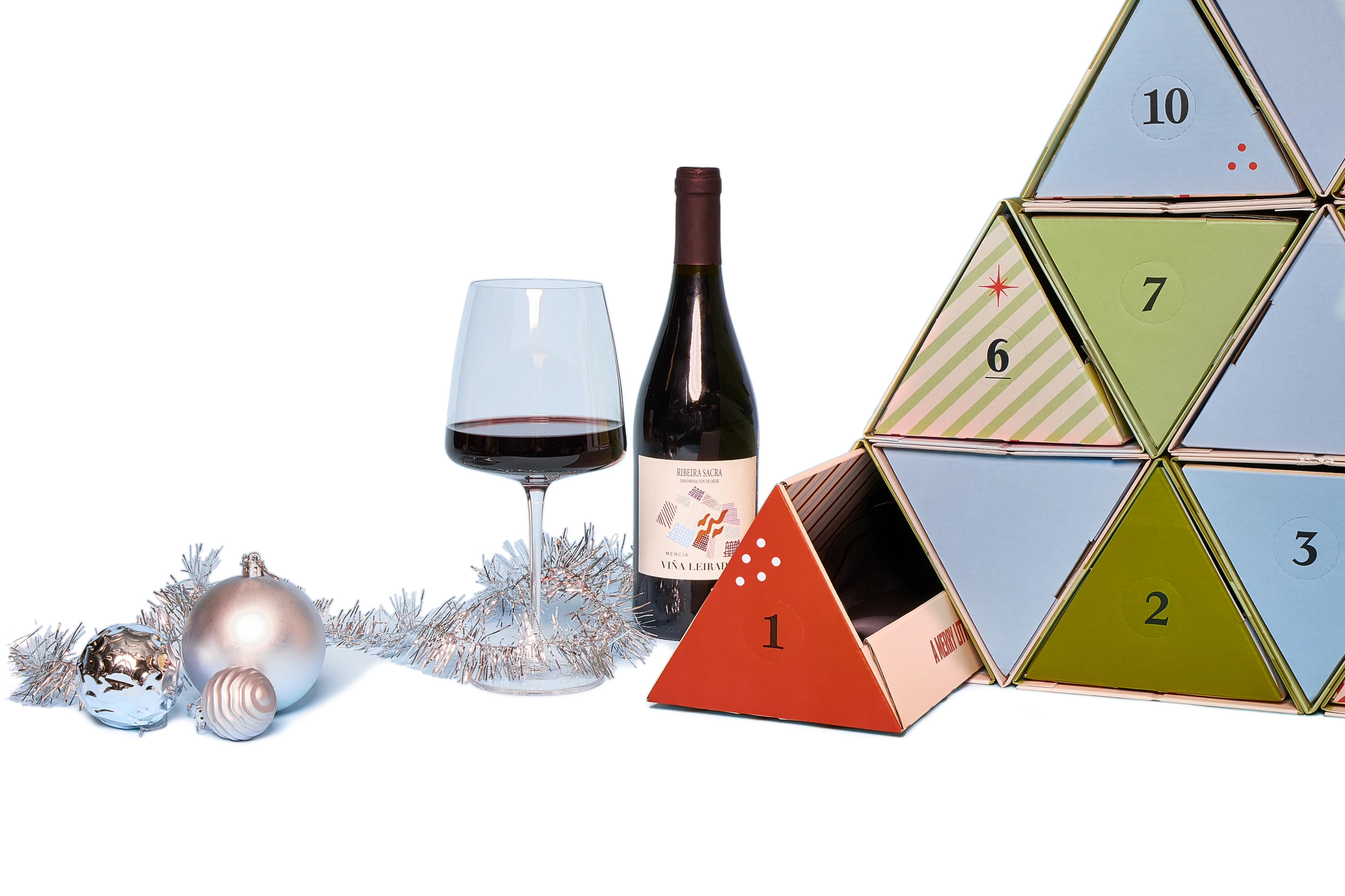 An opened Advent Calendar prism with a bottle of wine, a glass and Christmas decorations